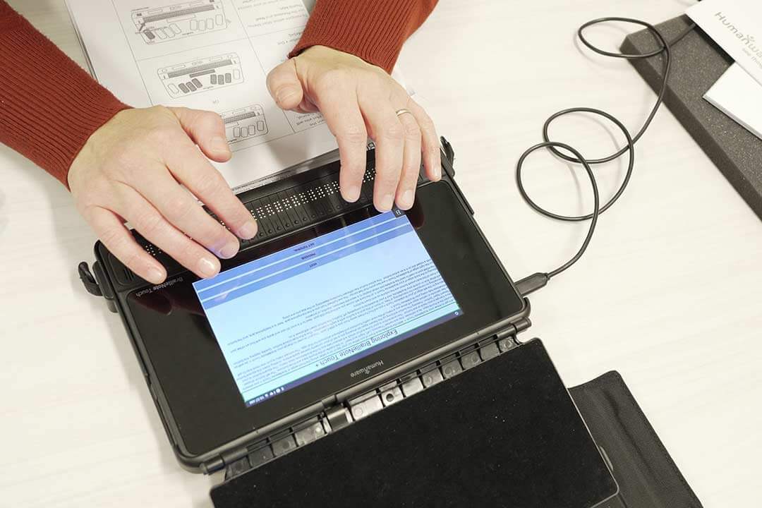 A educator placing her fingers on the BrailleNote Touch Plus