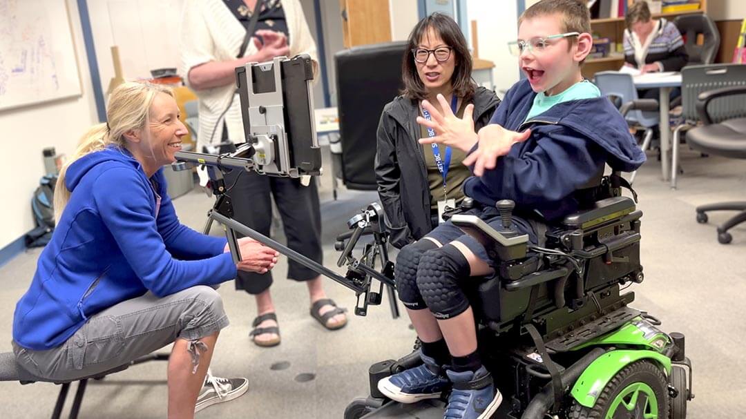 Liam with his new mounting system for his wheelchair. SET-BC OT and district OT having discussion on the mount.